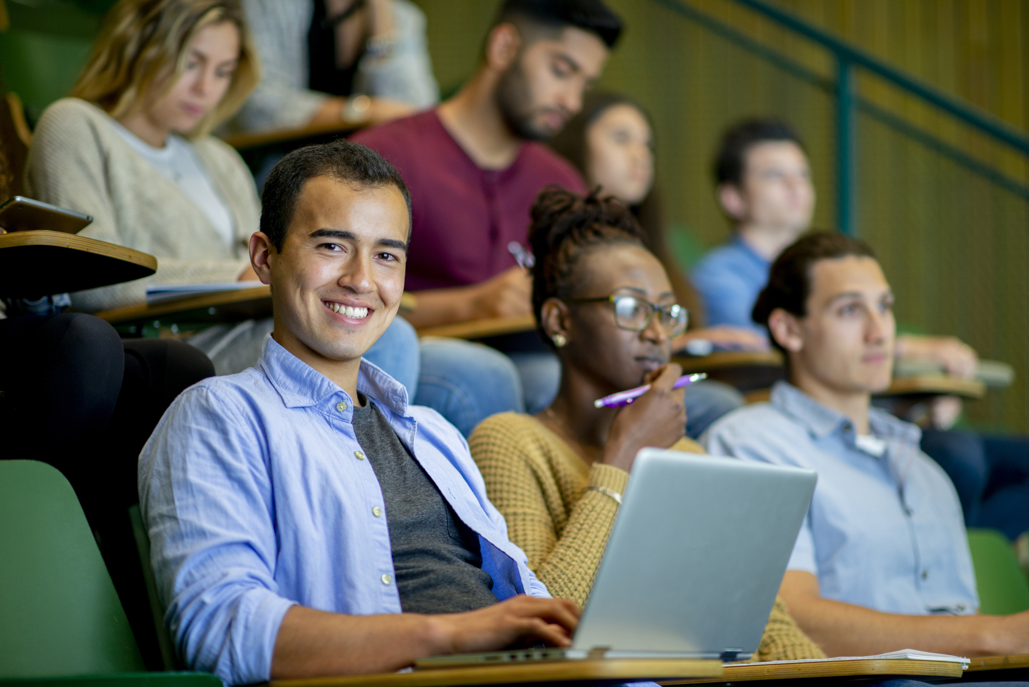 Male_Student_and_Students_in_College_Lecture_Hall.jpg